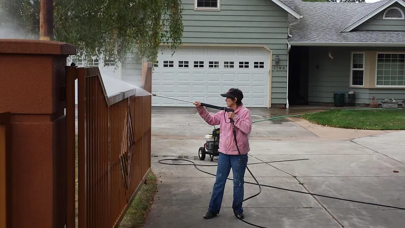 Janey power washing a fence